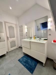 a bathroom with two sinks and a large mirror at Villa Alexandre III in Dijon