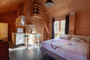une chambre avec un lit dans une cabane en bois dans l'établissement Studio en Bois avec jardin clos, à Bullion