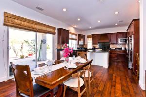 a kitchen with a wooden table with chairs and a large window at Poolside Bliss with elegant living #1 Rated in Palm Desert +65 photos