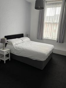 a bed in a bedroom with a large window at ashwood hotel in Preston