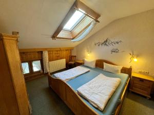 a bedroom with a large bed with a window at Pension Huber in Fischbachau