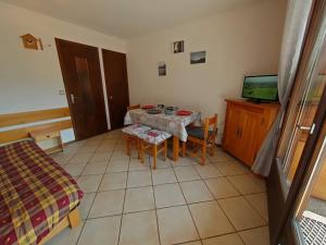 Camera piccola con tavolo e TV di Studio ski aux pieds avec terrasse, parking et Wi-Fi - 4 couchages - FR-1-241-173 a Le Grand-Bornand