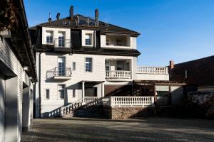 an old white building with a balcony on a street at Hotel Granit in Strzegom