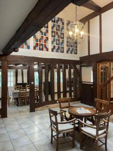 a dining room with a table and chairs and a chandelier at Les grandes bruyères in Lesperon