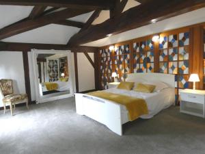 a bedroom with a large bed and a mirror at Les grandes bruyères in Lesperon