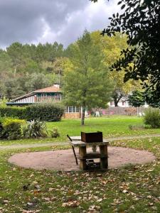 a picnic table and a bench in a park at Les grandes bruyères in Lesperon