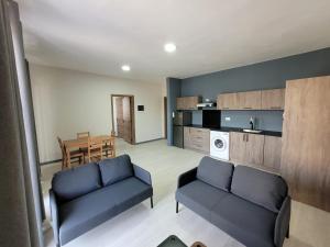 a living room with two blue couches and a kitchen at 2 Bed 9 mins walk from beach in Flic-en-Flac