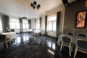 a dining room with tables and chairs and windows at Hotel Granit in Strzegom
