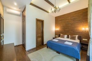 基辅佩特拉尼中心酒店的一间卧室设有蓝色的床和木墙