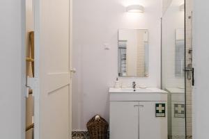a white bathroom with a sink and a mirror at Historic District lll in Alcácer do Sal +18 photos