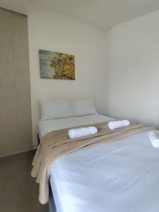a bed with two towels on top of it at Suíte 12 dupla com vista para o mar in Pontal do Paraná