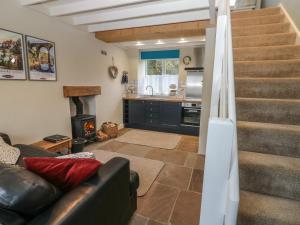 a living room with a couch and a staircase at Tyg Cottage in Grewelthorpe