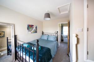 a bedroom with a bed with blue pillows at Tyg Cottage in Grewelthorpe