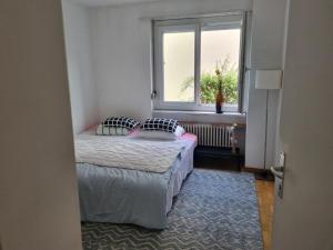 um pequeno quarto com duas camas e uma janela em Baselstrasse 51 em Lucerna