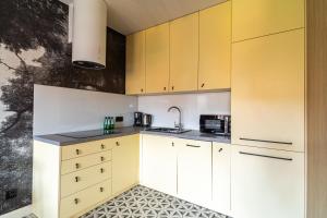 a kitchen with yellow cabinets and a sink at SPA Waterlane Island Deluxe 1 by Grand Apartments in Gdańsk