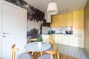 a kitchen with a white table and chairs at SPA Waterlane Island Deluxe 1 by Grand Apartments in Gdańsk