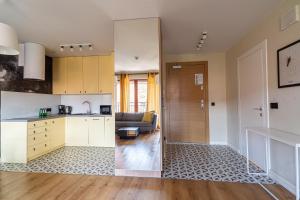 a kitchen and living room with a couch at SPA Waterlane Island Deluxe 1 by Grand Apartments in Gdańsk