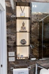 ein Badezimmer mit einem Regal, auf dem eine Statue steht in der Unterkunft Ginex Luxury Suite, Trani in Trani