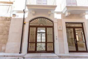 ein Gebäude mit einer großen Holztür mit Glas in der Unterkunft Ginex Luxury Suite, Trani in Trani