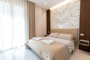 ein Schlafzimmer mit einem großen Bett mit Handtüchern darauf in der Unterkunft Ginex Luxury Suite, Trani in Trani