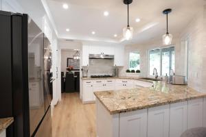 a kitchen with white cabinets and granite counter tops at Destination #50 in Placentia