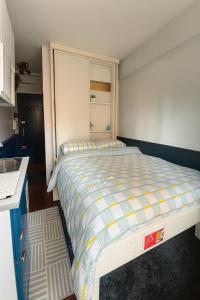 a small bedroom with a bed and a kitchen at The suspended cocoon in Le Havre