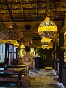 ein Restaurant mit Kronleuchtern, einem Tisch und Bänken in der Unterkunft Winston ocean heaven in Negombo
