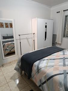 une chambre avec un lit et deux grands miroirs dans l'établissement Pousada da Cervejaria FAGATA, à Monteiro Lobato