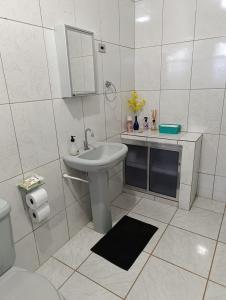 une salle de bain blanche avec un lavabo et des toilettes dans l'établissement Pousada da Cervejaria FAGATA, à Monteiro Lobato