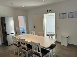 eine Küche mit Tisch und Stühlen und einem Kühlschrank in der Unterkunft OWL Comfort Homes - Porta Westfalica in Porta Westfalica + 13 Fotos