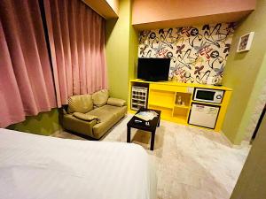 a room with a bed and a tv and a chair at ホテルクレアトゥール安城 in Anjomachi