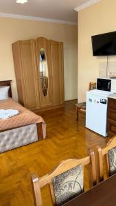 トラスコヴェッツにあるHerculesのベッド2台、テレビ、白い冷蔵庫のある部屋