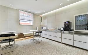 Una cocina con mesas y sillas en una habitación. en aiden, en Busan