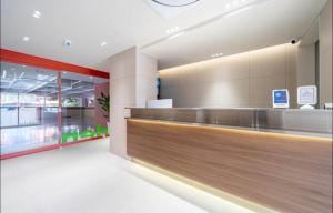 Un vestíbulo de tienda con un gran mostrador de recepción de madera en aiden, en Busan