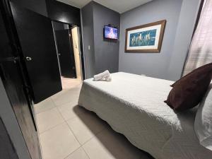 a bedroom with a bed and a tv on the wall at Aloha Rodadero in Gaira