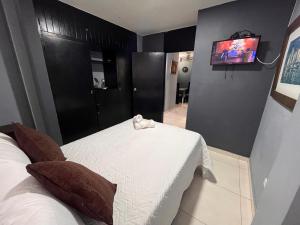 a bedroom with a bed and a tv on the wall at Aloha Rodadero in Gaira