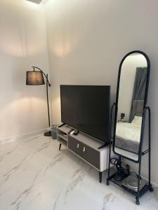 a living room with a tv and a mirror at استوديو الخبر - العزيزية in Al Khobar