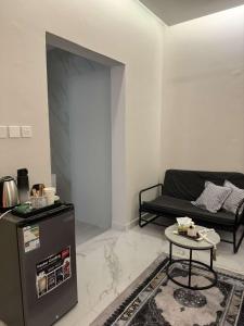 a living room with a black couch and a table at استوديو الخبر - العزيزية in Al Khobar
