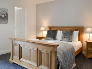 a bedroom with a wooden bed with two lamps at Fourwinds in Keswick