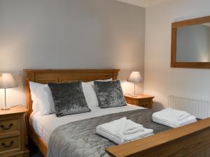 a bedroom with a large bed with two night stands at Fourwinds in Keswick +15 photos
