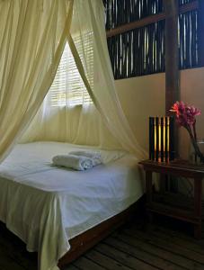 um quarto com uma cama com mosquiteiro em Playa Pikua Ecolodge em Guachaca mais 15 fotografias