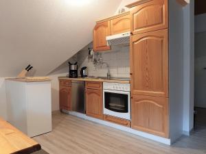 a kitchen with wooden cabinets and a stove top oven at Fewo Stricker 32 in Walkenried +29 photos