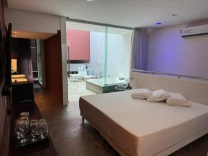 a bedroom with a large white bed and a bathroom at Sensacional Suíte no Union no Jacaré! in Ilha da Restinga +11 photos