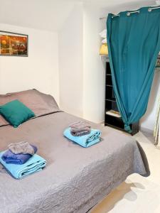 a bedroom with a bed with towels on it at Maison de village à Puybrun in Puybrun