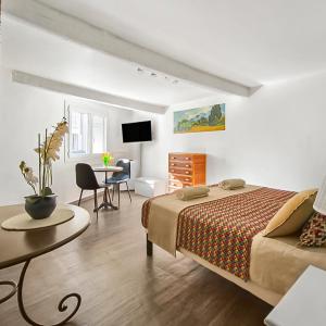a bedroom with a bed and a table and a desk at Les Amandiers - L'Isle d'Or in LʼIsle-sur-la-Sorgue