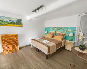 a bedroom with a bed and a painting on the wall at Les Amandiers - L'Isle d'Or in LʼIsle-sur-la-Sorgue