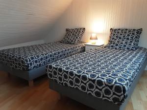 Dos camas una al lado de la otra en una habitación. en Le Gîte d’Ambre, en Locmaria-Berrien