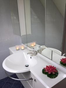 a white bathroom with a sink and a mirror at Ferienwohnung Ruheoase In Otterndorf in Otterndorf