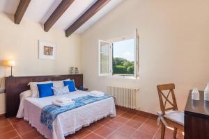 a bedroom with a bed and a window at Villa Mig Coster - Refugio rural en finca privada in Sant Lluis