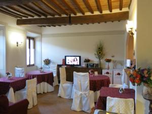 Pokój z dwoma stołami i krzesłami oraz telewizorem w obiekcie ROSSELLINO® w mieście Pienza
